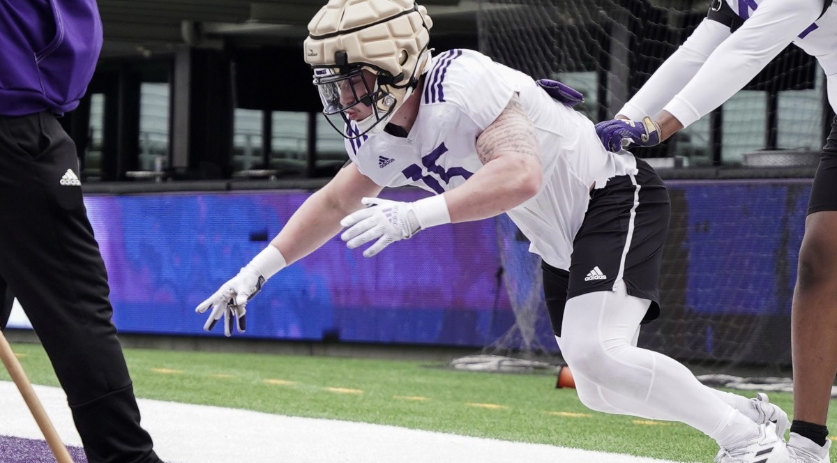 Zach Durfee runs through spring drill with resistance from a teammate.